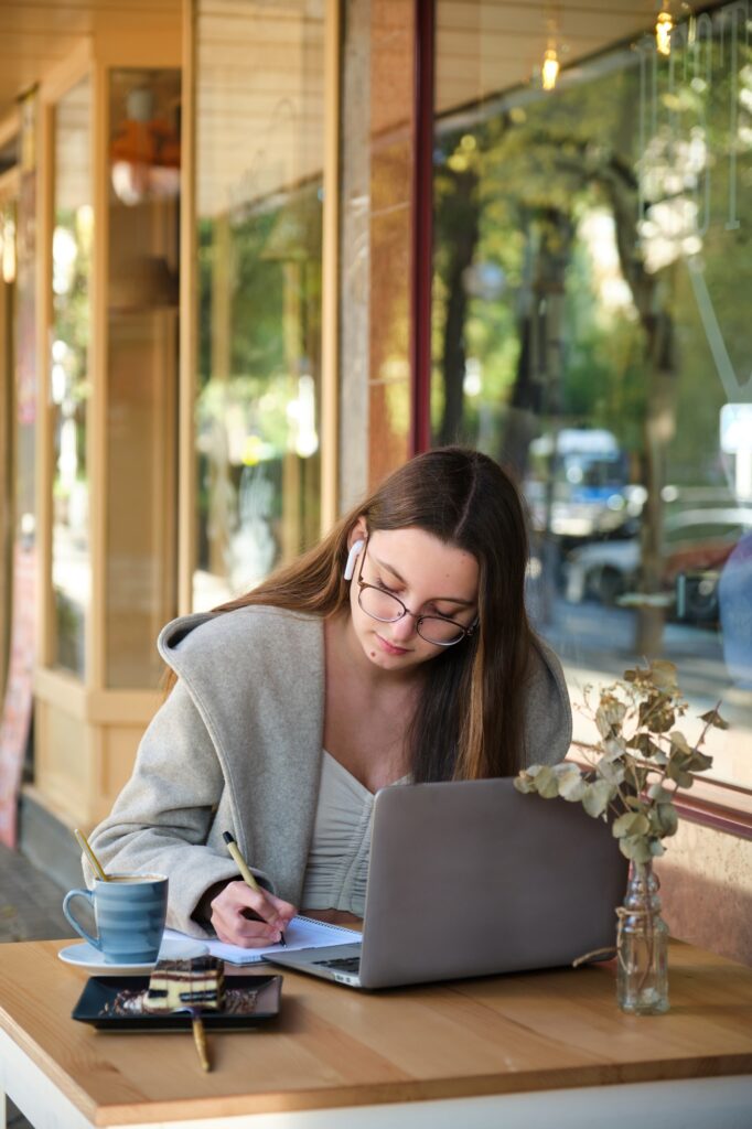 Business woman working remotely on a laptop in a coffee shop.